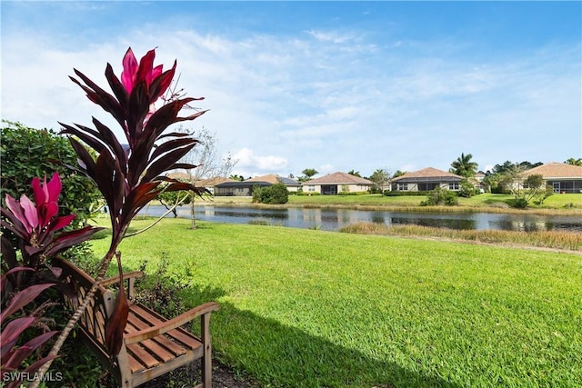 view of yard with a residential view and a water view