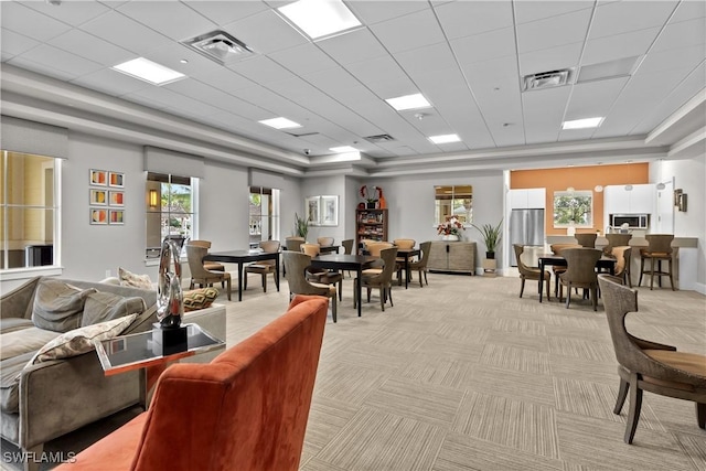 interior space featuring light carpet, a drop ceiling, and visible vents