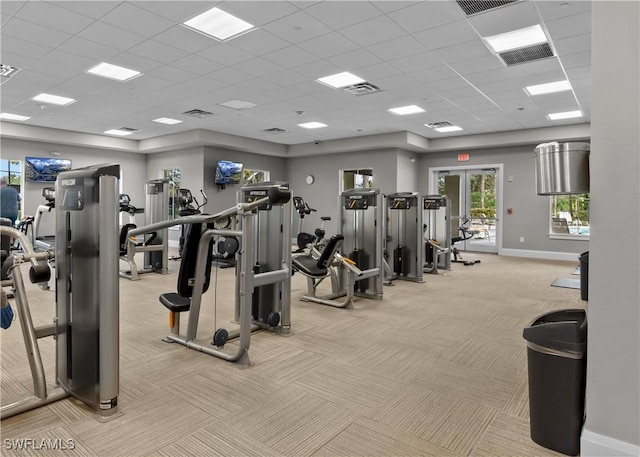 gym featuring baseboards, visible vents, and light colored carpet