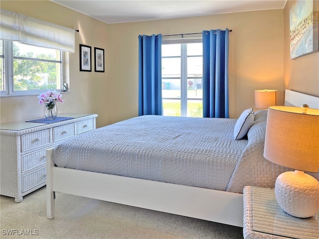 bedroom featuring light carpet and multiple windows