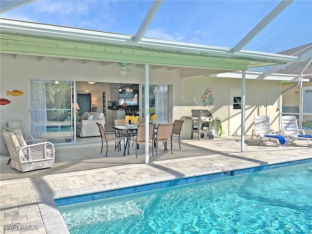 outdoor pool featuring ceiling fan, glass enclosure, and a patio area