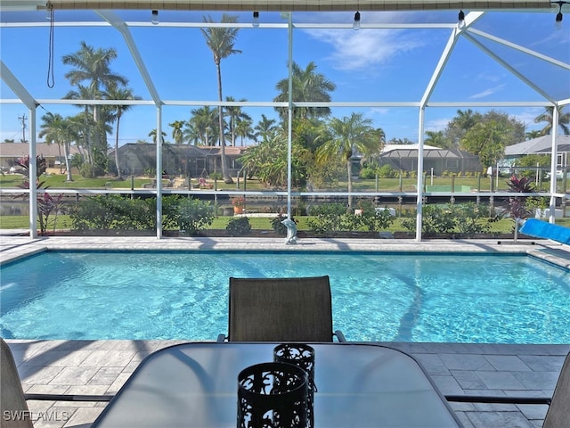 pool featuring glass enclosure, a patio, and a residential view