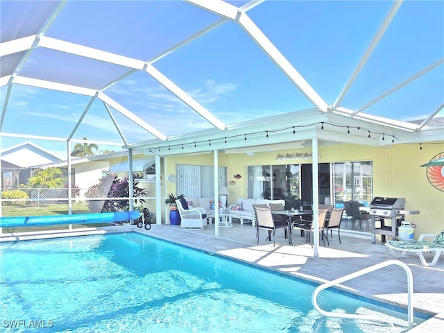 pool featuring a patio area, glass enclosure, and grilling area