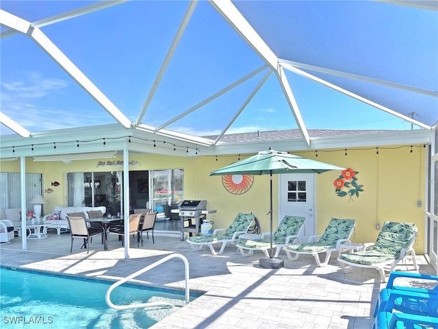 rear view of house with a patio, stucco siding, a lanai, and an outdoor pool