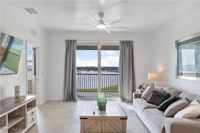 living room with a water view, light tile patterned floors, visible vents, and a ceiling fan