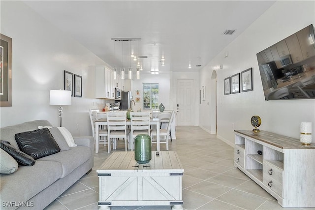 living room featuring visible vents, baseboards, and light tile patterned flooring