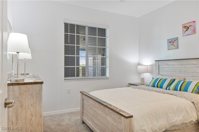 bedroom with light colored carpet and baseboards