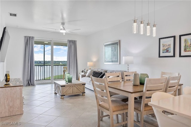 dining area with light tile patterned floors, visible vents, and a ceiling fan