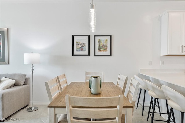 dining area featuring light tile patterned flooring and baseboards