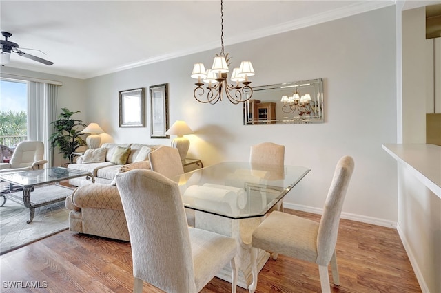 dining area with ornamental molding, ceiling fan with notable chandelier, baseboards, and wood finished floors