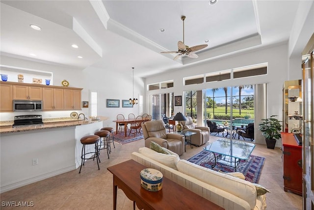 6574 Caldecott Dr, Naples, FL 34113 - living room with a towering ceiling, light tile patterned floors, ceiling fan, and a tray ceiling