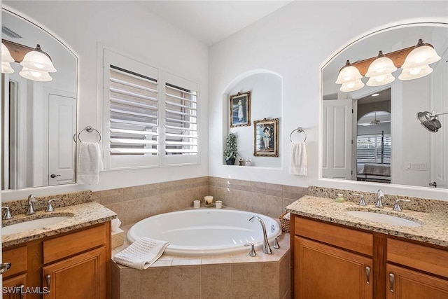 6574 Caldecott Dr, Naples, FL 34113 - full bathroom featuring two vanities, a sink, and a bath
