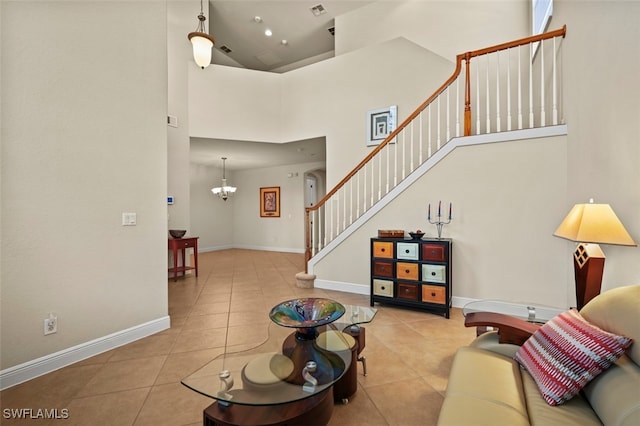 living area featuring baseboards, a high ceiling, stairway, and light tile patterned flooring