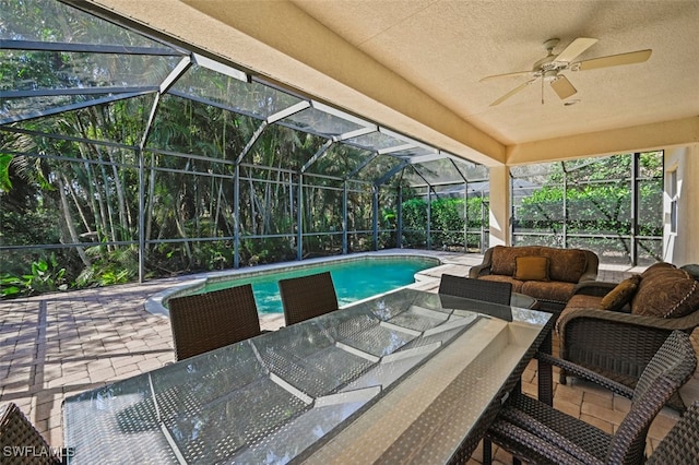 pool with a patio, glass enclosure, and an outdoor living space