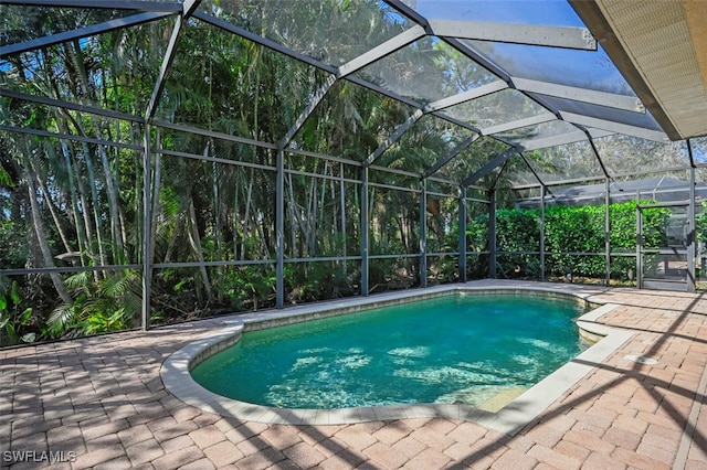 outdoor pool featuring glass enclosure and a patio