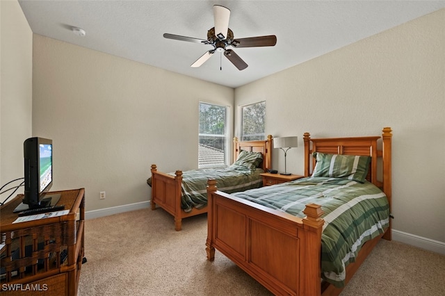 bedroom with a ceiling fan, light colored carpet, and baseboards