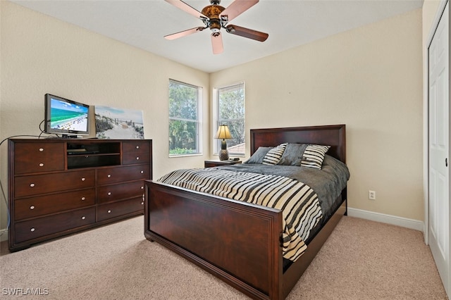 bedroom featuring baseboards, ceiling fan, and light colored carpet