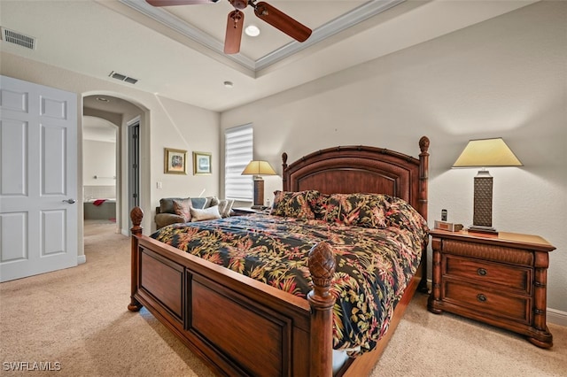 bedroom featuring arched walkways, light carpet, a raised ceiling, and visible vents