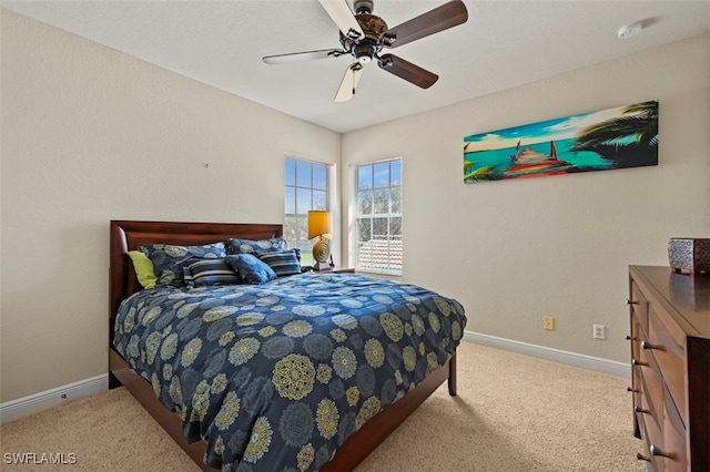 bedroom featuring light carpet, baseboards, and a ceiling fan