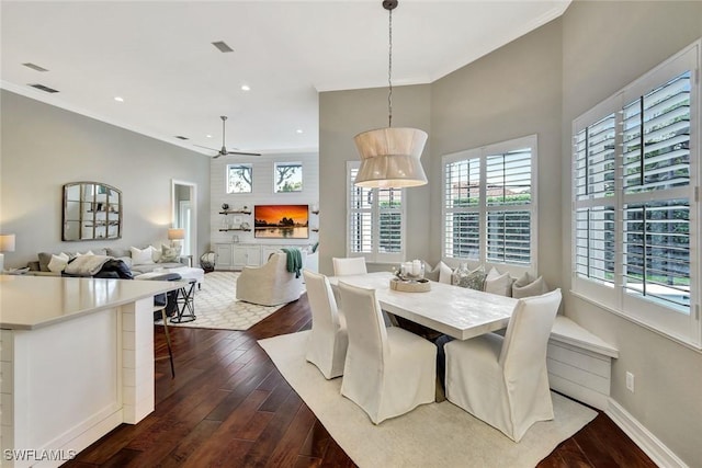 dining area with crown molding, dark wood-type flooring, visible vents, and baseboards