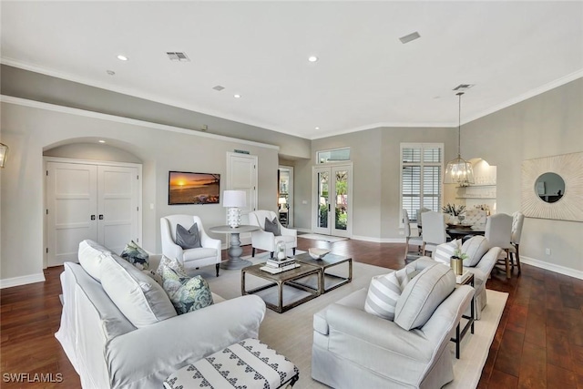 living area featuring baseboards, visible vents, arched walkways, and wood finished floors