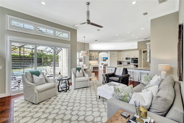 living area featuring recessed lighting, wood finished floors, a ceiling fan, and crown molding