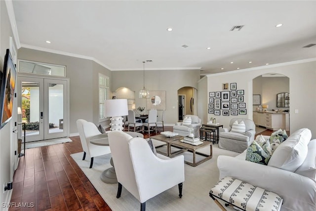 living area featuring arched walkways, recessed lighting, wood finished floors, visible vents, and french doors