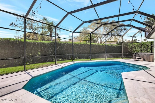 pool featuring glass enclosure, a patio, and a hot tub