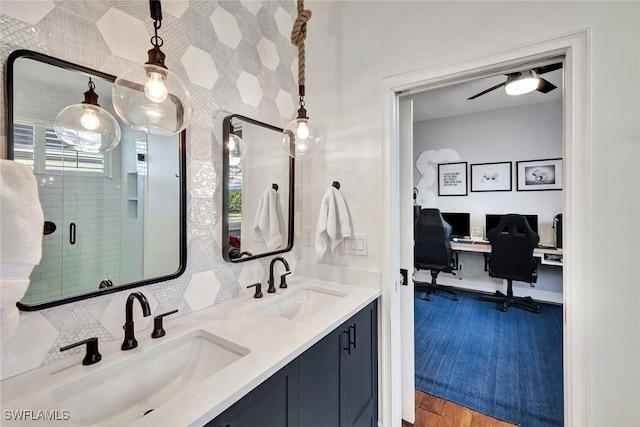 full bath with wood finished floors, a shower with door, a sink, and double vanity