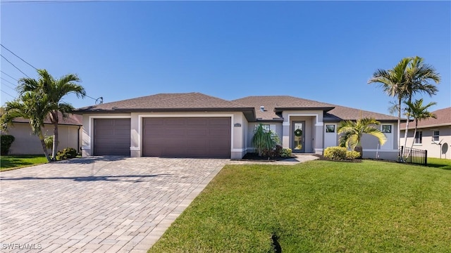 prairie-style house with a front lawn, decorative driveway, an attached garage, and stucco siding