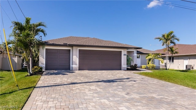 view of front of house with an attached garage, a front lawn, decorative driveway, and stucco siding