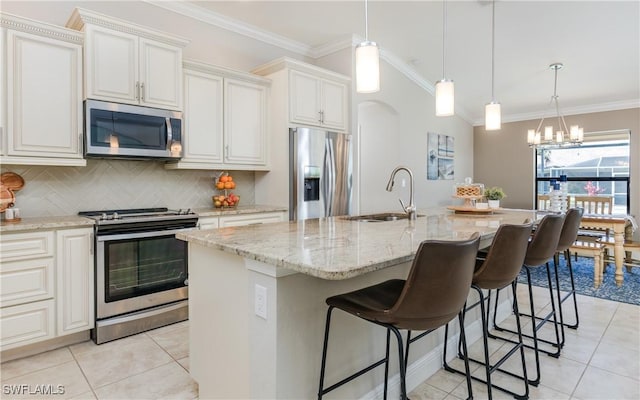 kitchen featuring a center island with sink, appliances with stainless steel finishes, crown molding, white cabinetry, and a sink