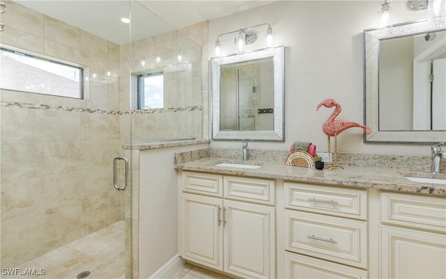 full bathroom featuring double vanity, tile patterned flooring, a shower stall, and a sink