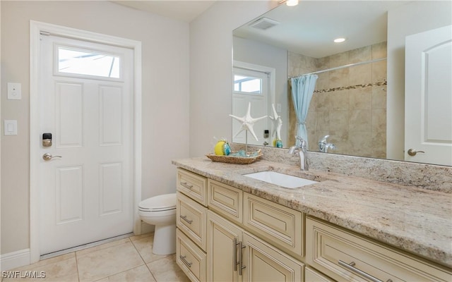 bathroom with visible vents, toilet, vanity, tile patterned flooring, and tiled shower