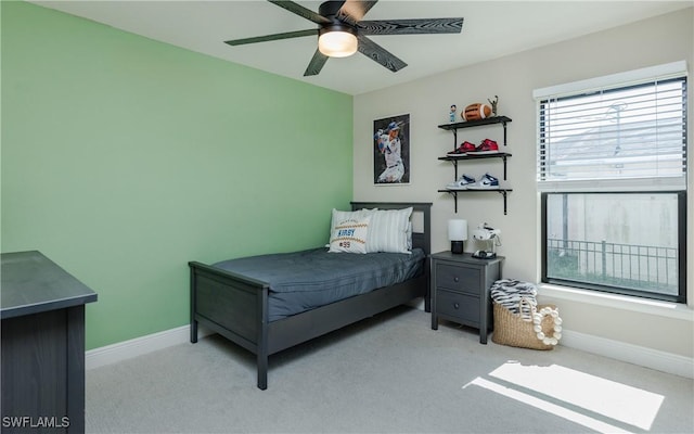 bedroom featuring a ceiling fan, light colored carpet, and baseboards