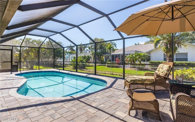 pool with glass enclosure and a patio area