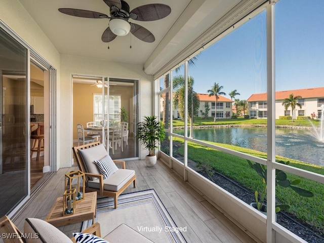 sunroom / solarium featuring a water view and ceiling fan