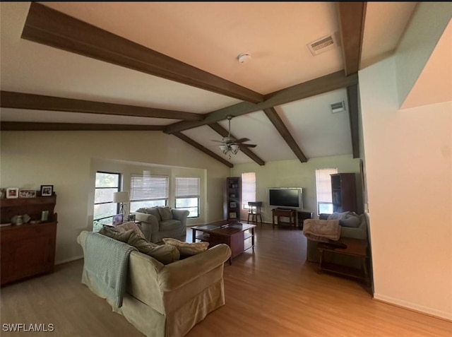 living area featuring visible vents, lofted ceiling with beams, wood finished floors, baseboards, and ceiling fan