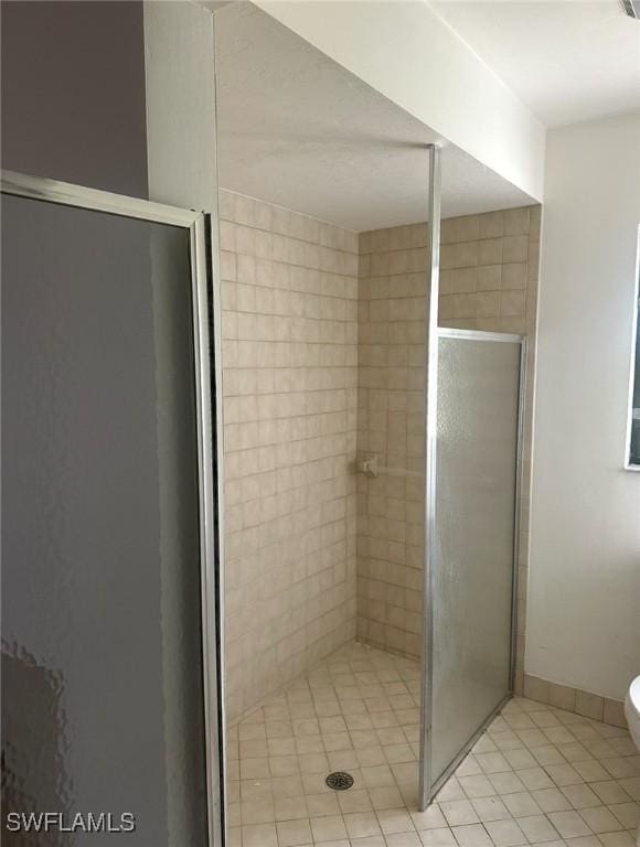 bathroom featuring a stall shower, toilet, and baseboards