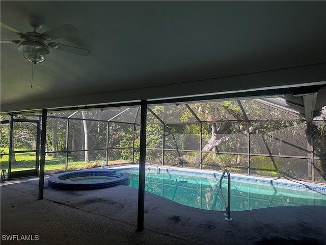 view of swimming pool with glass enclosure, a patio, a pool with connected hot tub, and a ceiling fan