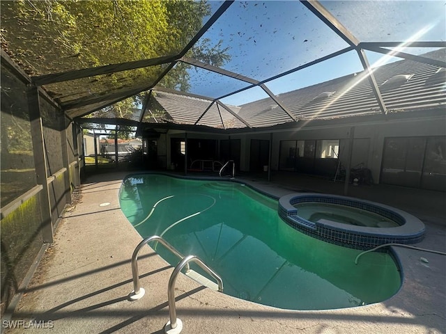 view of swimming pool featuring a patio area, glass enclosure, and a pool with connected hot tub