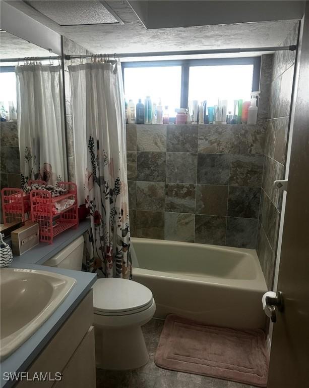 bathroom with toilet, vanity, and shower / bath combo