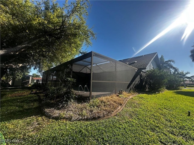 view of side of property with a lanai and a yard