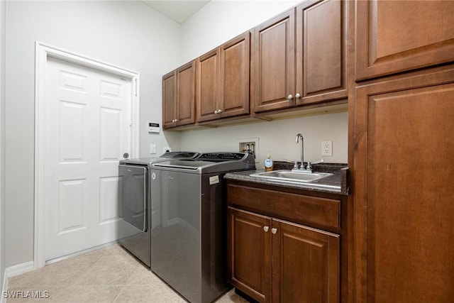 laundry area with light tile patterned floors, separate washer and dryer, a sink, and cabinet space