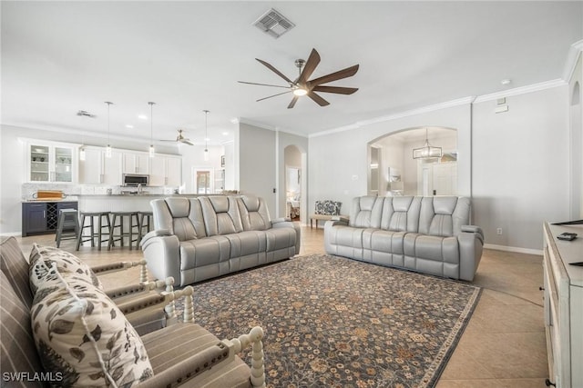 living room with light tile patterned floors, visible vents, arched walkways, baseboards, and ceiling fan