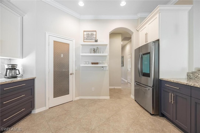 kitchen with arched walkways, open shelves, smart refrigerator, white cabinetry, and light stone countertops