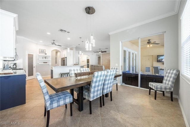 dining room featuring arched walkways, visible vents, ornamental molding, light tile patterned flooring, and ceiling fan