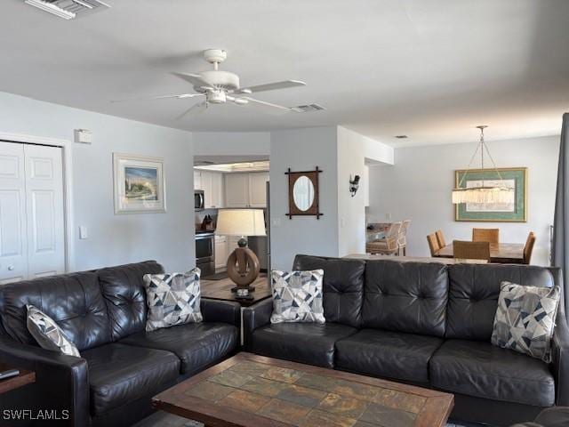 living area with visible vents and ceiling fan