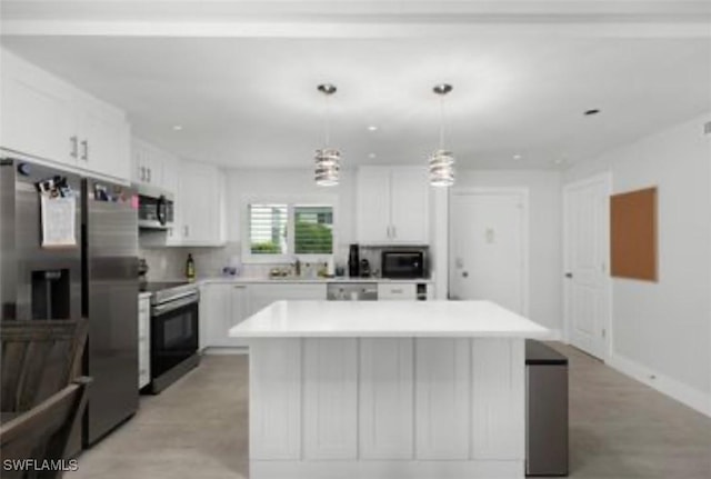 kitchen with light countertops, appliances with stainless steel finishes, white cabinetry, and a center island