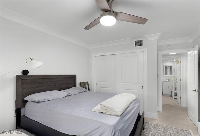 bedroom with crown molding, a closet, visible vents, ceiling fan, and wood finished floors